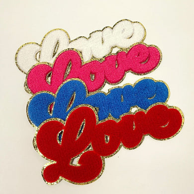 4 Chenille Patches that say Love in a script font, stacked partially on top of one another so you can see all four colors. They are stacked from top to bottom, white, pink, blue and red.